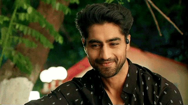 a man with a beard wearing a black shirt with white polka dots