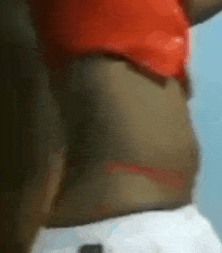 a woman in a red top and white shorts is standing