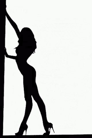 a silhouette of a woman standing next to a pole .