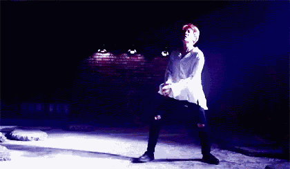 a man is doing a trick on a wall in the dark .