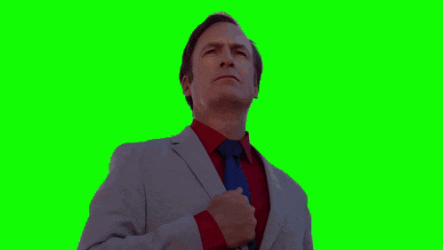 a man in a suit and tie stands in front of a large flag