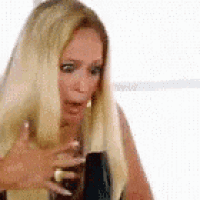 a woman with long blonde hair is holding a black object .