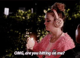 a woman wearing headphones and a pink fur coat is holding a candle and saying `` omg are you hitting on me ''