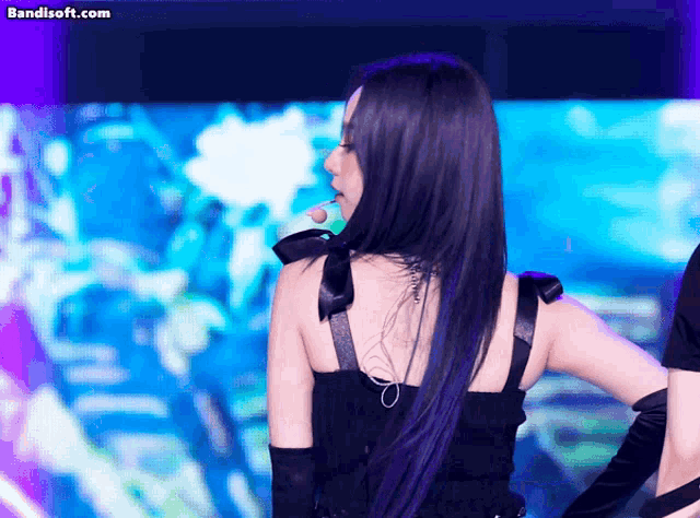 a woman with purple hair is dancing on a stage and the website bandisoft.com is visible in the corner