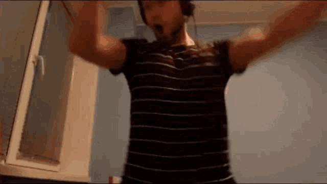 a man wearing headphones is dancing in a room .