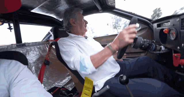 a man is sitting in a car with a tag that says mg