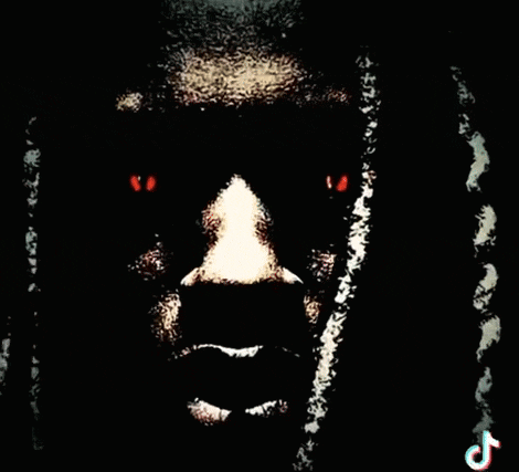 a close up of a man 's face with dreadlocks and red eyes