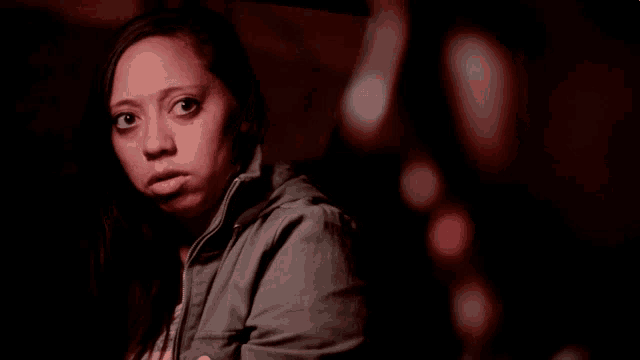 a woman in a gray jacket looks at the camera