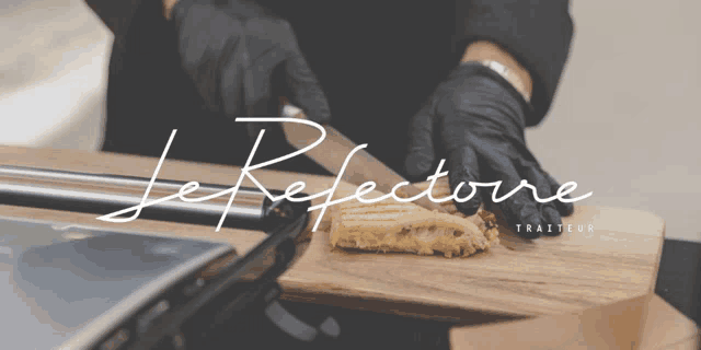 a person wearing black gloves is cutting a piece of food on a wooden cutting board that says le refletore traiteur