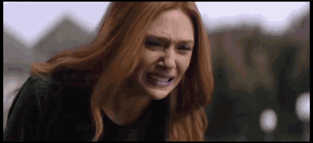 a woman with red hair is crying and making a face .