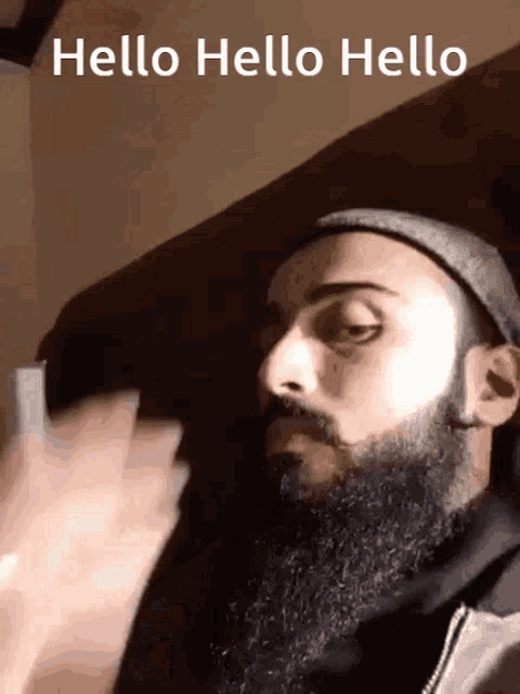 a man with a beard wearing a hat and jacket says hello hello hello