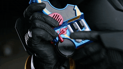 a person wearing black gloves is holding a toy that looks like a keyboard