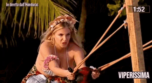 a woman in a hawaiian outfit is holding a slingshot in front of a sign that says " viperissima "