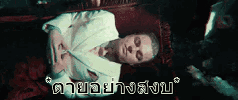a woman in a white robe is laying on a bed with the words " ตาย อย่าง สบ " written on the bottom