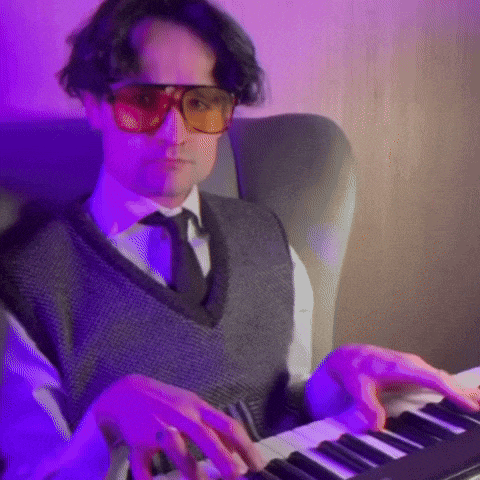a man wearing sunglasses is playing a keyboard .