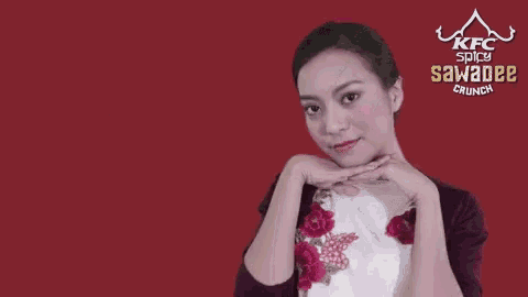 a woman with her eyes closed and a kfc spicy sawadee crunch advertisement behind her