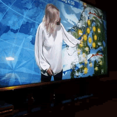 a woman stands in front of a screen that says dag kl 08 on it