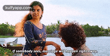 a man is proposing to a woman in front of a body of water and says if somebody sees marriage will happen right away .