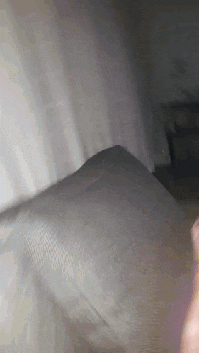 a person 's hand is holding a piece of paper in front of a wall