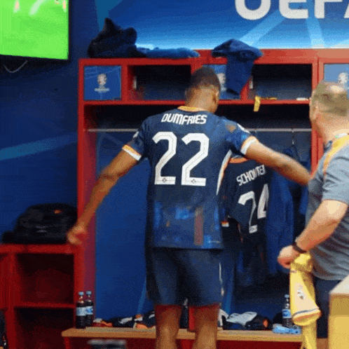 a soccer player in a locker room with the number 22 on his jersey