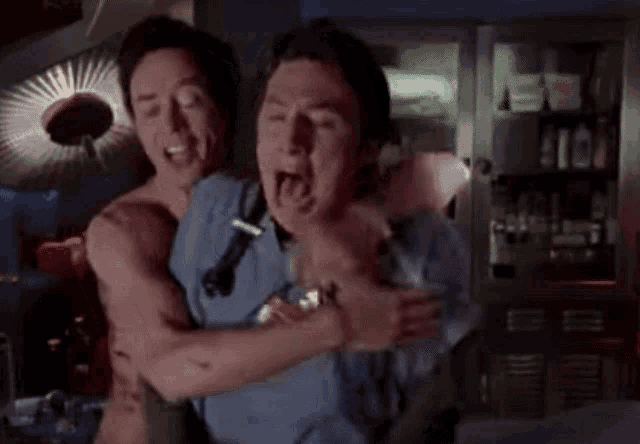 two men are hugging each other with their mouths open and one has a stethoscope around his neck