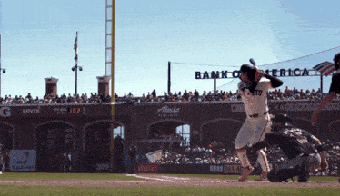 a baseball player swings at a pitch in front of a sign that says bank of america