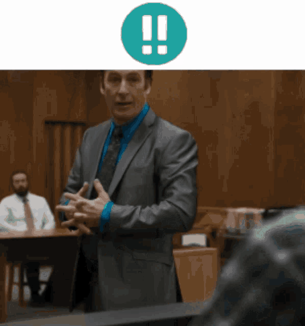 a man in a suit and tie stands in front of a green exclamation mark