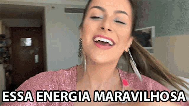 a woman is smiling with the words essa energia maravilhosa written above her