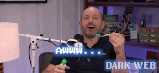 a man is holding a toothbrush in front of a microphone with the words awww dark web above him