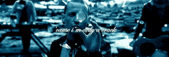a man holding a piece of glass with the words " cause i 'm only a crack " behind him