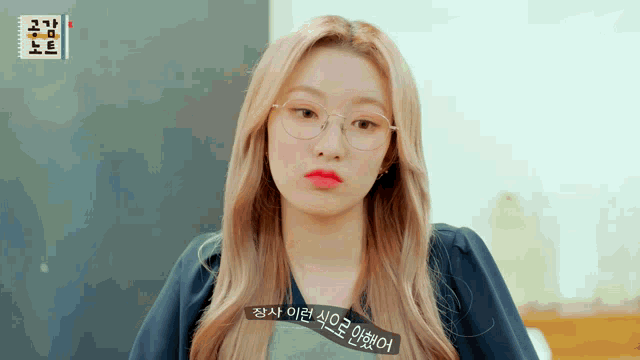 a woman wearing glasses has a sticker on her shirt that says ' korean ' on it