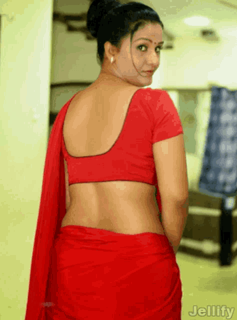 a woman wearing a red blouse and a red saree has jellyify written on the bottom right