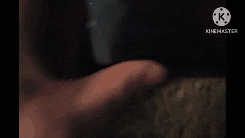 a close up of a person 's hand holding a black object with a purple light coming out of it .