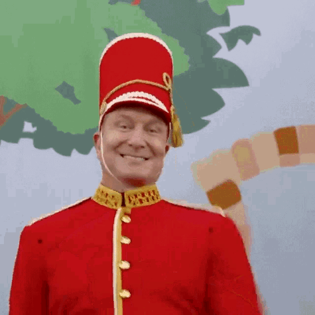 a man in a red uniform with a red hat smiles