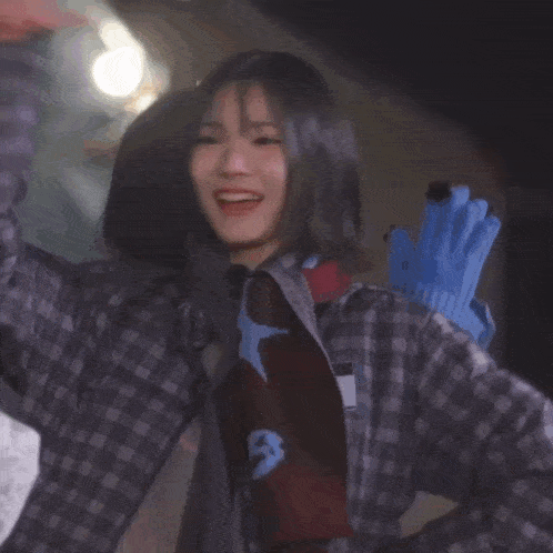 a girl in a plaid shirt is smiling in front of a sign that says ' korean ' on it