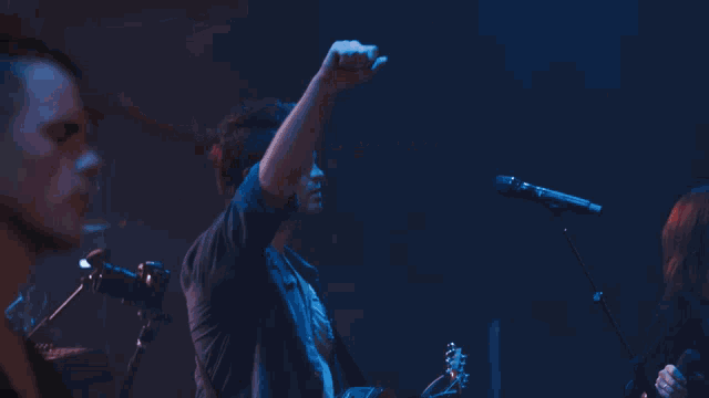a blurred image of a person holding a microphone in a dark room