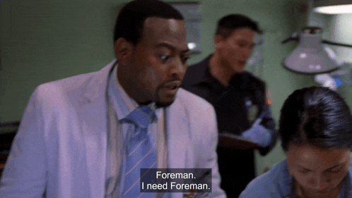 a man in a lab coat and tie says foreman