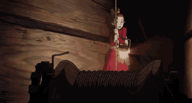 a cartoon girl is sitting in a dark room holding a book .
