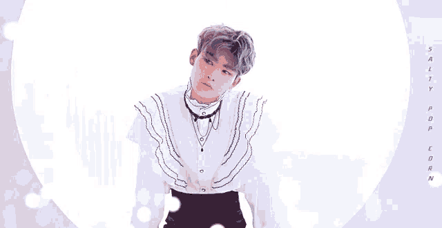 a young man in a white shirt and black pants is standing in front of a white circle .