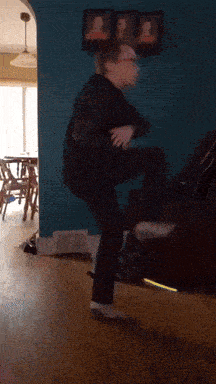 a person is standing on a couch in front of a blue wall