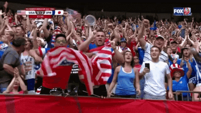 a crowd of people watching a soccer game with fox on the bottom