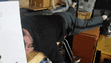 a man is laying on his back in a room with boxes and a box that says ' a1 ' on it