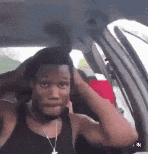 a man is sitting in a car with his hands on his head
