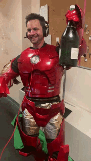 a man in an iron man costume holds a bottle of champagne