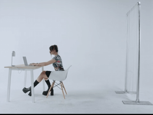 a woman sitting at a desk with a laptop on it