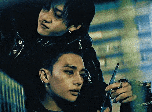 two men are standing next to each other and one is holding a gun .