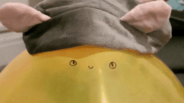 a yellow balloon with a drawing of a face on it