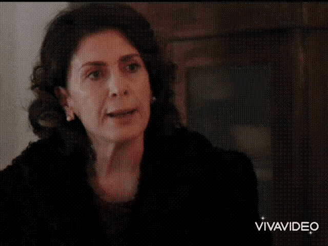 a woman wearing a headband and a red shirt is looking at the camera with vivavideo in the corner .