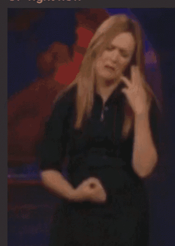a woman in a black shirt is talking on a phone