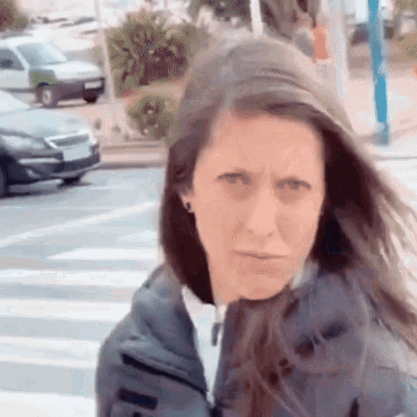 a woman in a black jacket is standing in front of a car